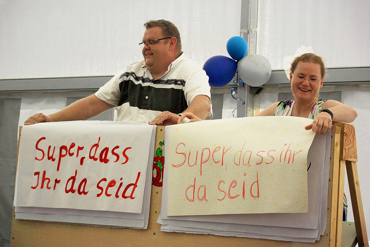 Thorsten und Steffi begrüßen die Gäste mit Plakattexten