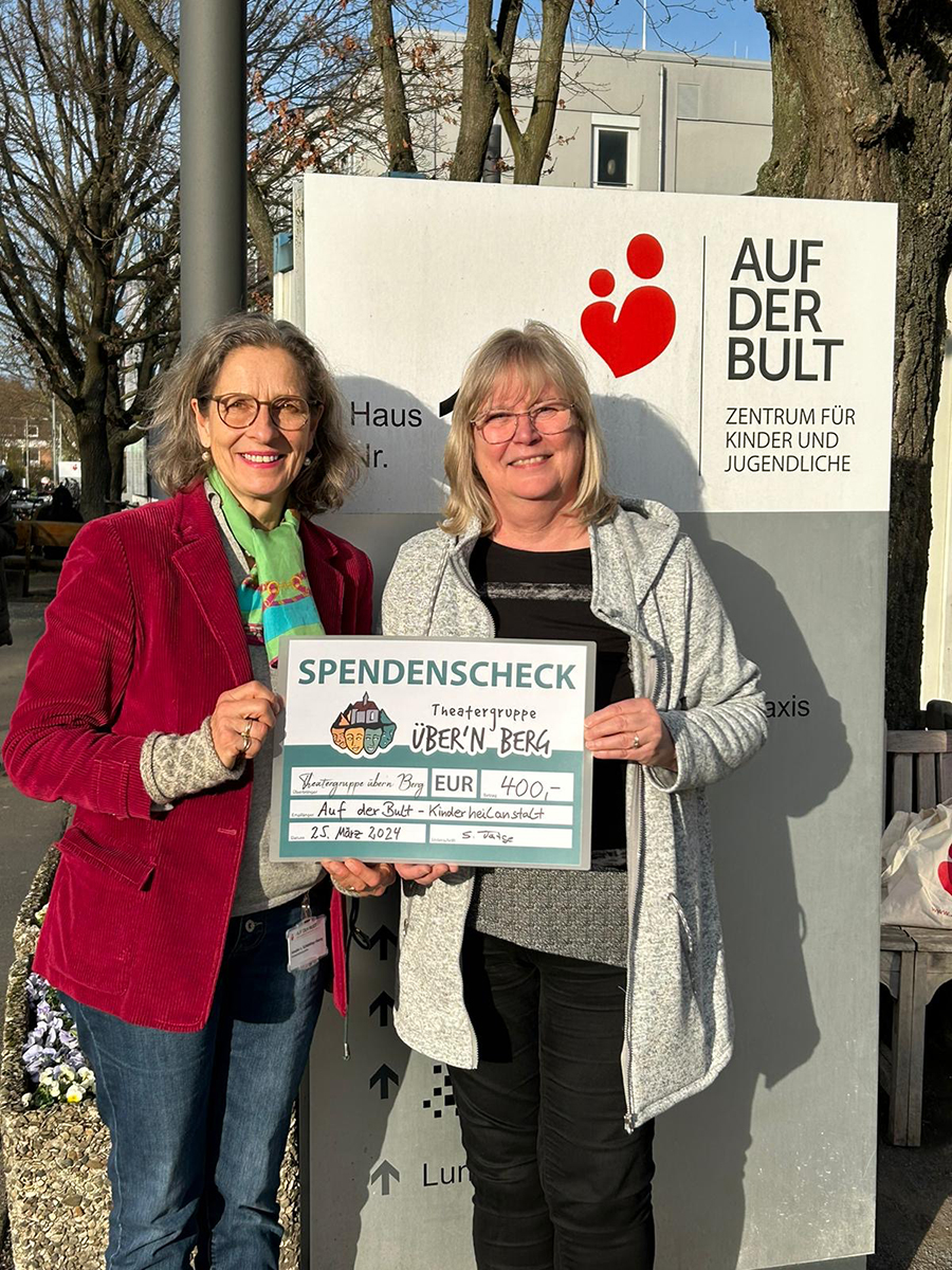 Der symbolische Spendencheck wird an die Mitarbeiterin der Krankenhauses übergeben.